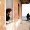 Woman looking out of the window at a man leaving her house