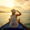 Woman traveling by boat at sunset among the islands.